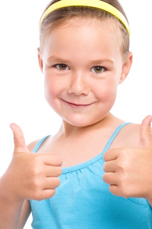Little girl dressed in blue is showing thumb up gesture using both hands, isolated over whiteの写真素材