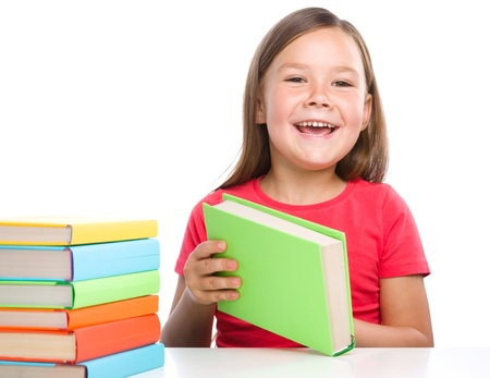 Cute little girl is reading a book, isolated over whiteの写真素材