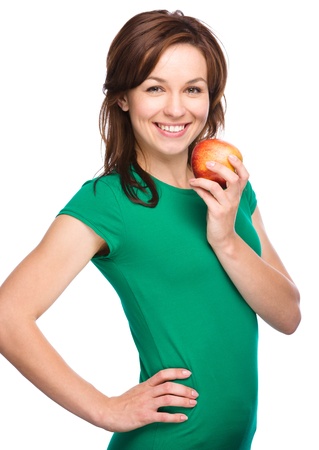 Young happy girl is holding red apple, isolated over whiteの写真素材