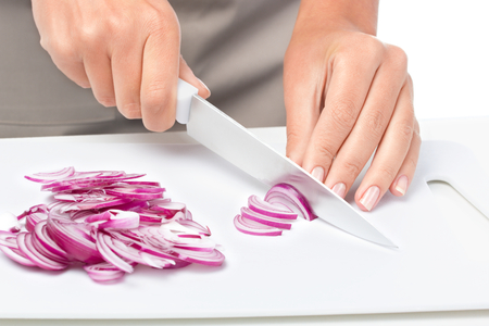 Cook is chopping onion, closeup shoot, isolated over whiteの写真素材