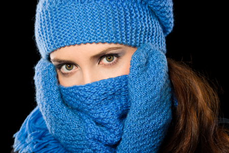 Young happy woman wearing winter cloth, isolated over blackの写真素材