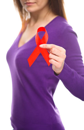 Woman is holding the red awareness ribbon, isolated over whiteの写真素材
