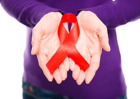 Woman is holding the red awareness ribbon, isolated over whiteの写真素材