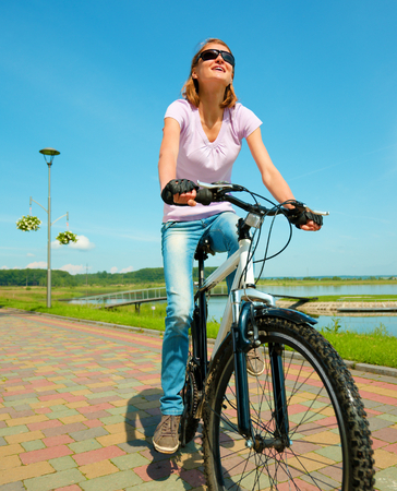 Young happy woman is sitting on her bicycle, outdoor shootの写真素材