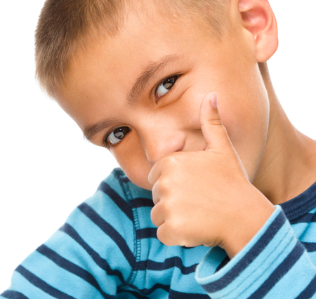 Cute little boy is showing thumb up sign, isolated over whiteの写真素材