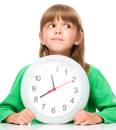Little girl is holding big clock, isolated over whiteの写真素材