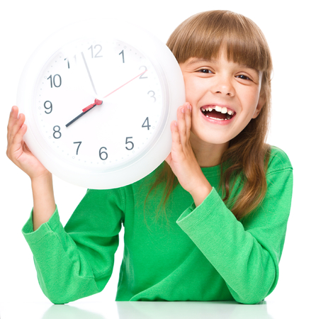 Little girl is holding big clock, isolated over whiteの写真素材