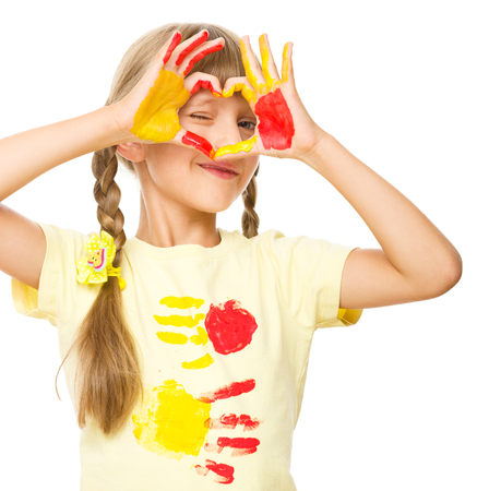 Portrait of a cute girl showing her hands painted in bright colors, isolated over whiteの写真素材