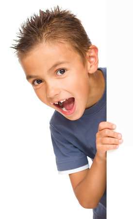 Little boy is looking out from the blank banner, isolated over whiteの写真素材