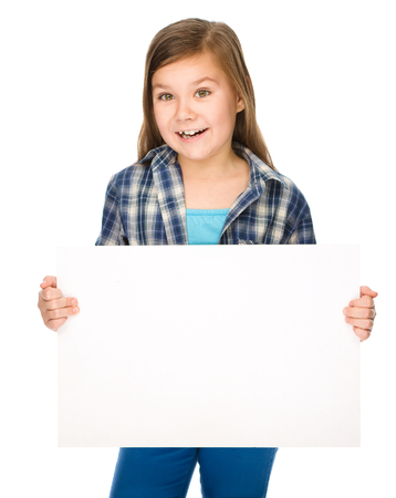 Little girl is holding a blank banner, isolated over whiteの写真素材