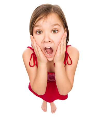Little girl is holding her face in astonishment and looking up, fisheye portrait, isolated over whiteの写真素材