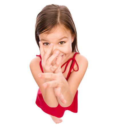 Little girl in red dress showing big nose, mocking, fisheye portrait, isolated over whiteの写真素材