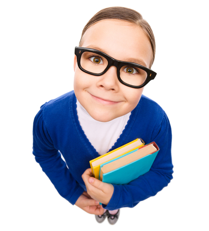 Funny little girl is holding books, fisheye portrait, isolated over whiteの写真素材