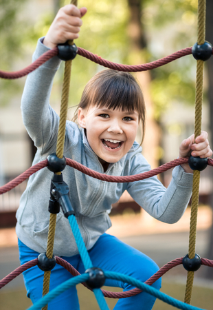 Cute little girl is playing in playground, outdoor shootの写真素材