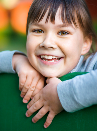 Cute little girl is playing in playground, closeup shoot, outdoorの写真素材
