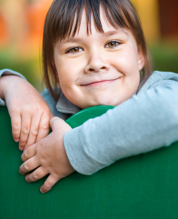 Cute little girl is playing in playground, closeup shoot, outdoorの写真素材