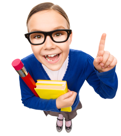Funny little girl is holding books and explaining something pointing with her index finger, fisheye portrait, isolated over whiteの写真素材