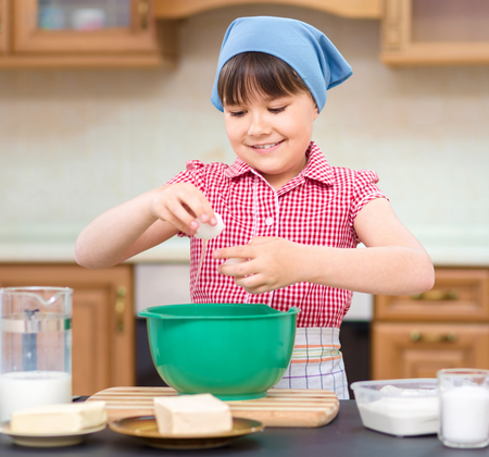 Girl is cooking, breaking eggs, indoor shootの写真素材