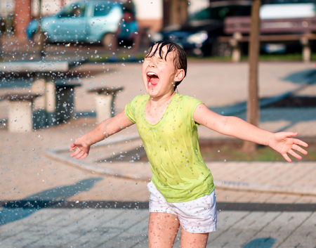 Hot summer in the city - girl is running through fountainsの写真素材