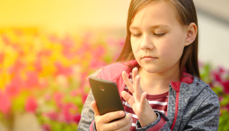 Girl is reading something on a phoneの写真素材