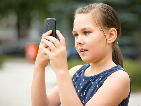 Girl is shooting photo using smartphone, outdoor shootの写真素材