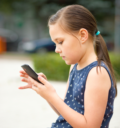 Girl is using smartphone, outdoor shootの写真素材