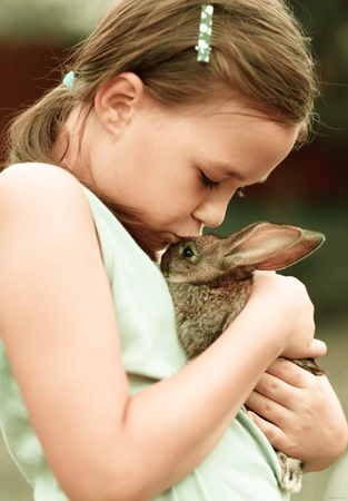 Girl is holding a cute little rabbit, outdoor shootの写真素材