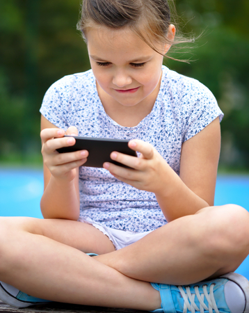 Girl is using smartphone, outdoor shoot