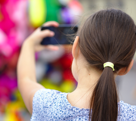 Girl is shooting photo using smartphone, outdoor shootの写真素材
