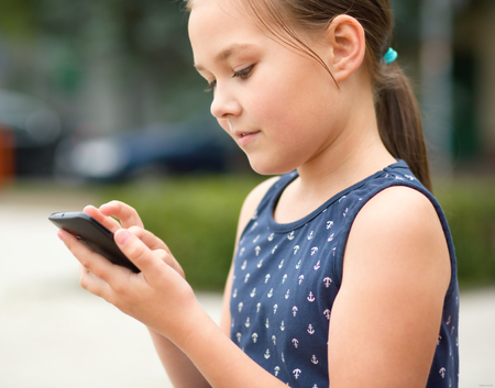 Girl is using smartphone, outdoor shootの写真素材