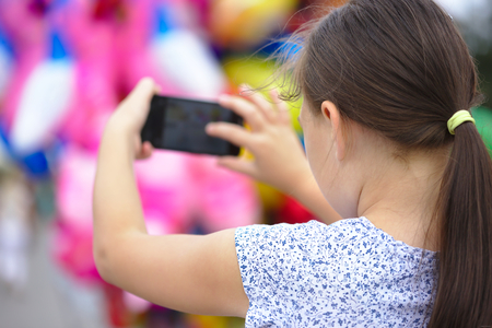 Girl is shooting photo using smartphone, outdoor shootの写真素材