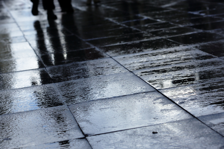 Silhouettes on wet road tiles shallow depth of field, outdoor shootの写真素材
