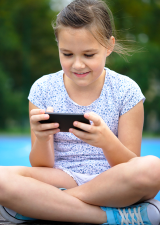 Girl is using smartphone, outdoor shootの写真素材
