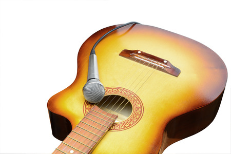 Silver microphone lays on acoustic guitar on a white backgroundの写真素材