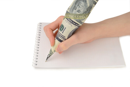 Female hand writing on paper pen dollars on a white backgroundの写真素材