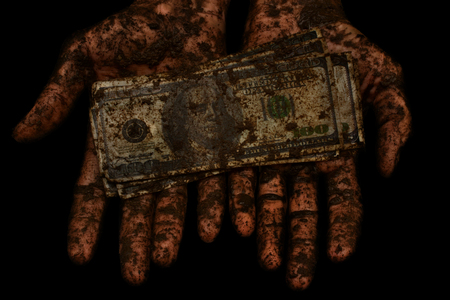 dirty money is not clean hands  on a black backgroundの写真素材