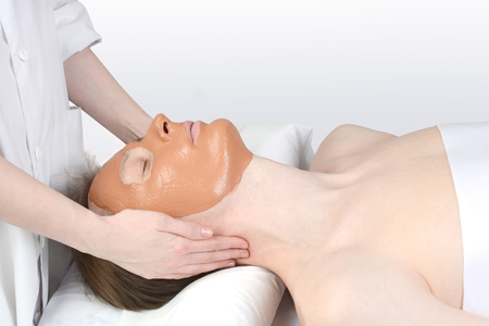 woman made a mask out of clay on the man's faceの写真素材