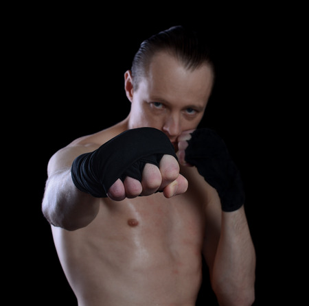 Male fighter in fighting stance. boxer on a black background out of focusの写真素材