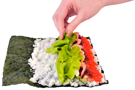 Girl is making sushi. Cook food. Japanese food. Rolls - culinary.の写真素材