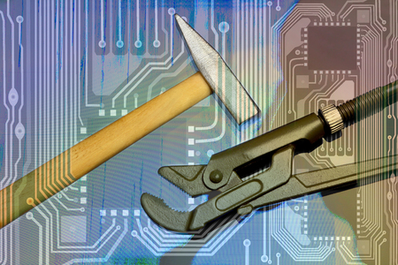 Service maintenance of computer equipment. Conceptual background for electronic repair. Hammer and adjustable key on the background of the wiring diagram and the Damaged monitor screenの写真素材