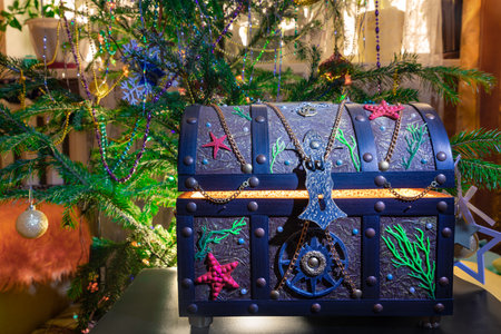 Gift glowing chest on the background of a Christmas tree. Wealth concept for holidayの写真素材