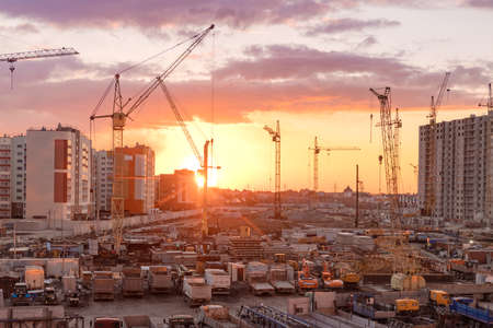 city Barnaul. Russia. April 22, 2021. Construction of residential buildings from reinforced concrete and bricks. Tower cranes at sunset. Enthusiasts st. Industrial zone. Construction machineryのeditorial素材