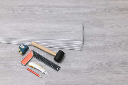 Laminate flooring. Repair floor work. Tools for laying parquet and laminate, vinyl boards.の写真素材