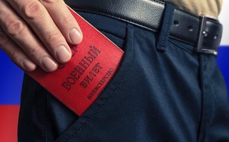 Man puts the Military ID in his pants pocket. Mobilization in the Russian Federation. Fixed term...