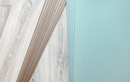 Background of laid laminate and sheet heat and noise insulation. Repair and decoration of premises. Modern flooring. Wood texture. Plank connection. Close-up.の写真素材