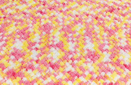 Knitted warm blanket. Background of a woven soft blanket, handmade. Texture of colored yarn.