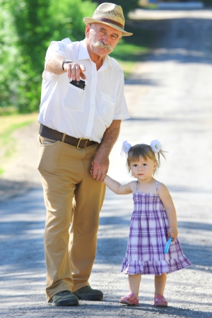 grandfather and granddaughter are on the roadの写真素材