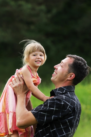 Beautiful little girl with her father on the natureの写真素材