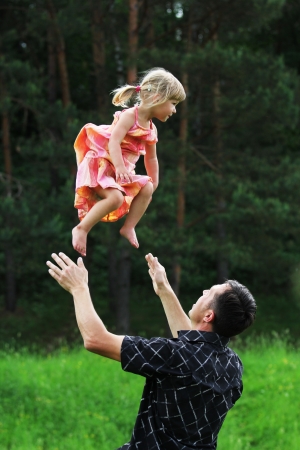 Beautiful little girl with her father on the natureの写真素材