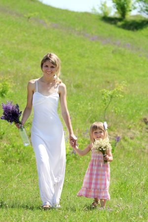 Beautiful little girl with her mother on the natureの写真素材